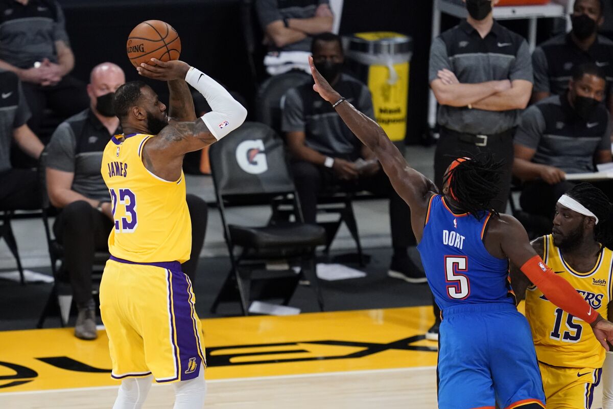 Lakers forward LeBron James makes a three-pointer against the Thunder to tie the score at the end of the fourth quarter.