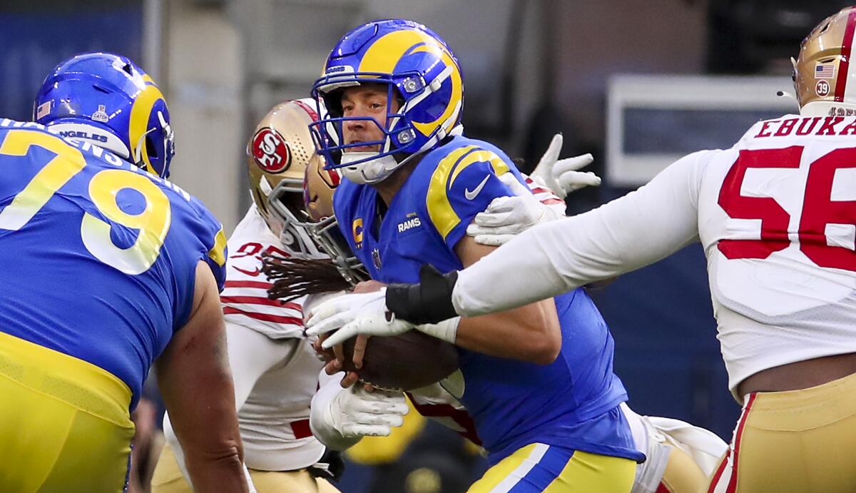 Rams quarterback Matthew Stafford is sacked by 49ers linebacker Fred Warner in the third quarter. 