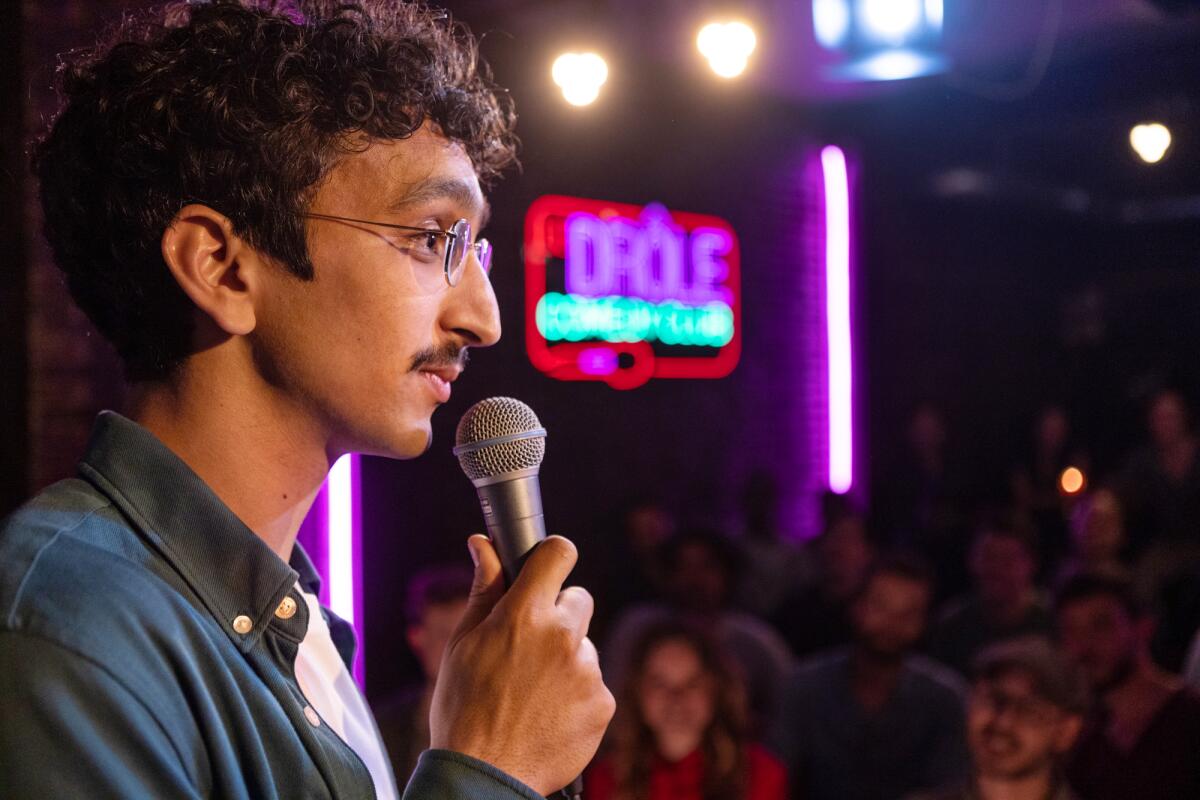 A man performs stand-up at a Parisian comedy club