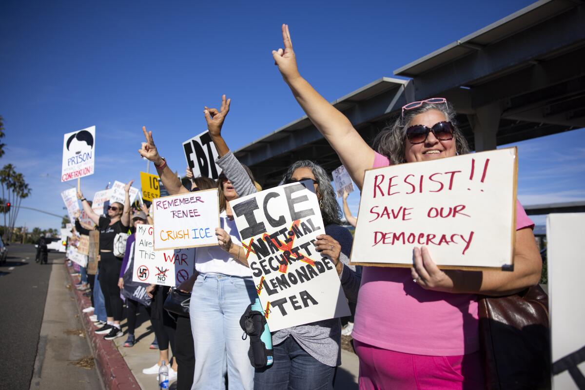 Protestors hold signs along a street.