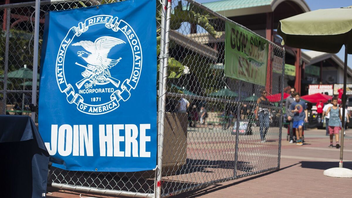 A National Rifle Assn. banner is displayed near the entrance of a Crossroads of the West Gun Show at the OC Fair & Event Center in Costa Mesa in October. Orange County Fair Board members voted Thursday to approve contracts for three more shows this year.