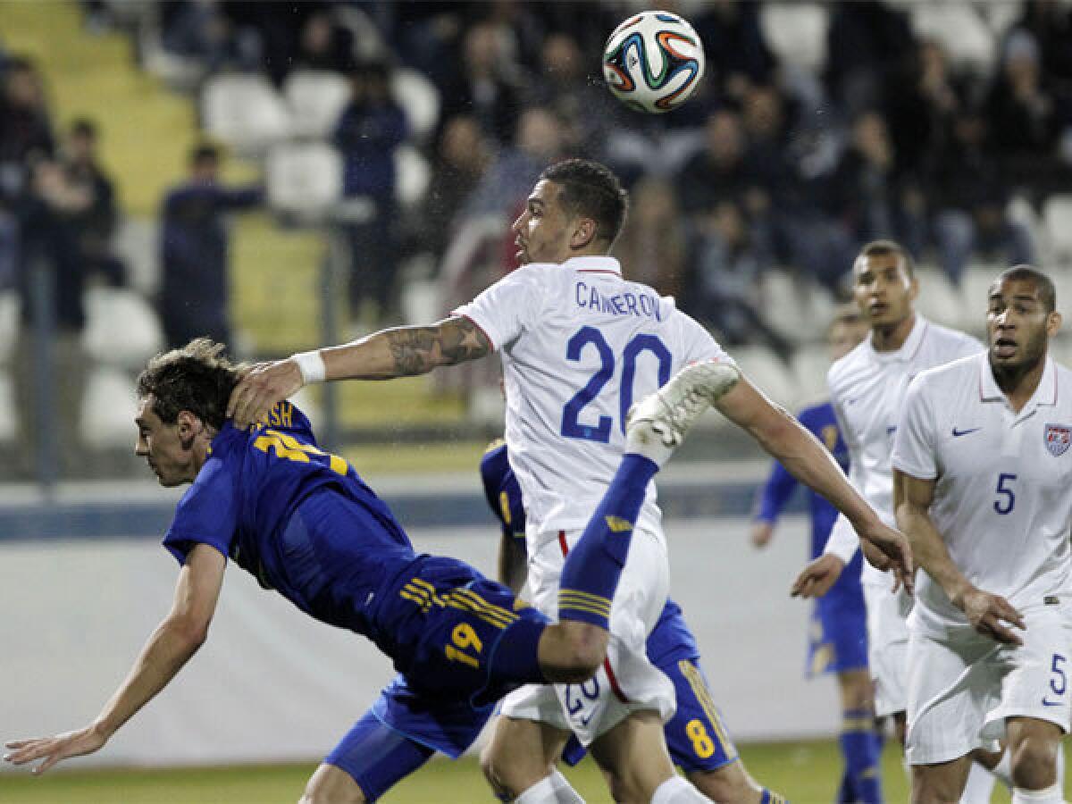 Ukraine's Denys Garmash, left, goes after the ball against Geoff Cameron of the U.S. during an international friendly match at Antonis Papadopoulos stadium in Cyprus.