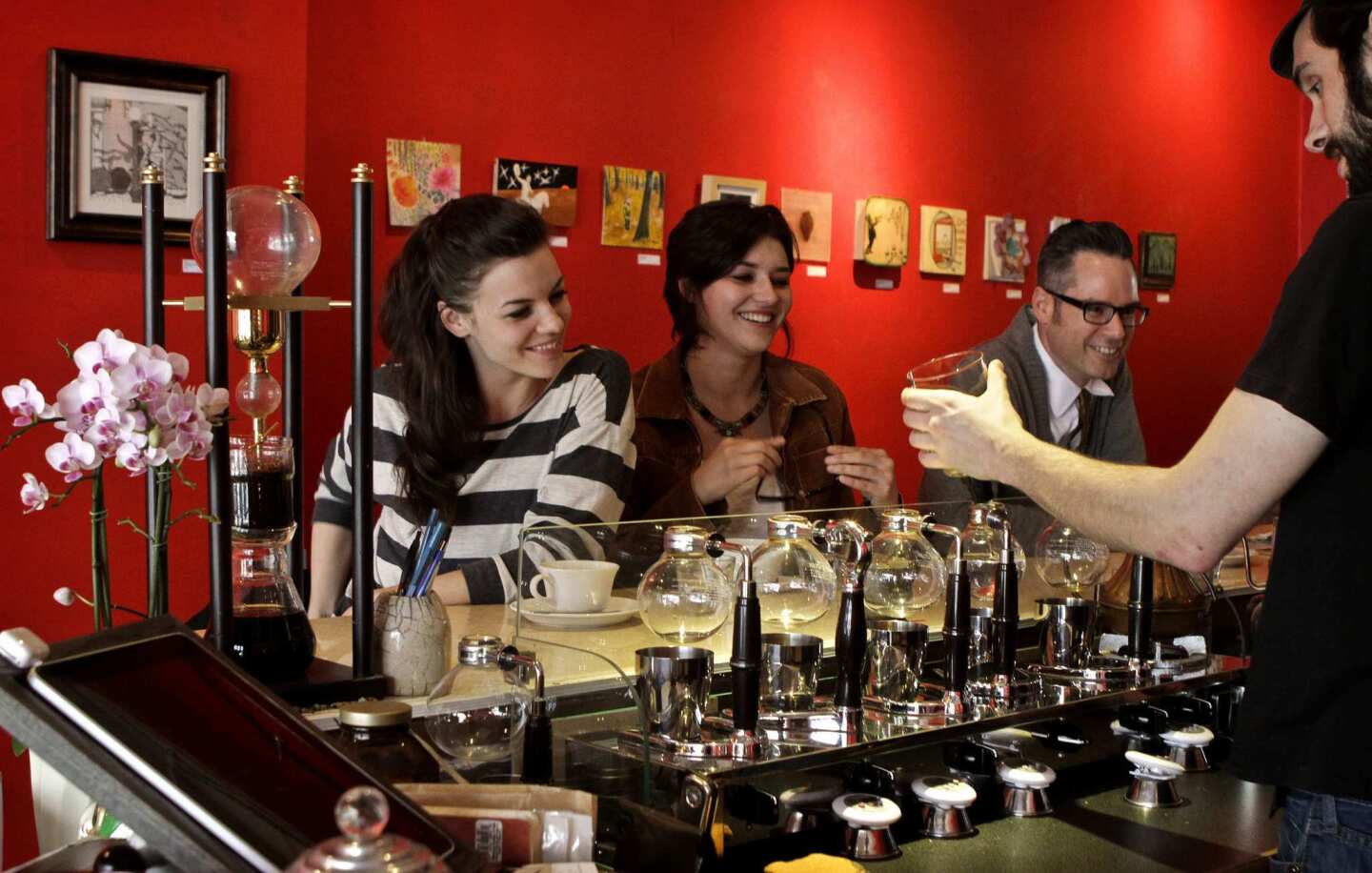 Customers have a laugh with barista Peter Molignano, who is brewing coffee in the siphon coffee bar at Balconi Coffee Co.