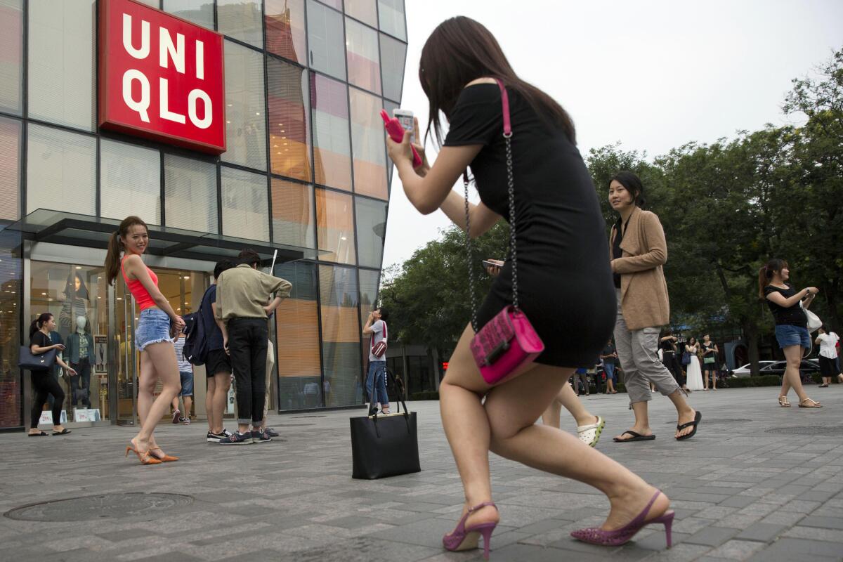 A woman poses for a photo outside the Uniqlo flagship store where a steamy video was purportedly taken.