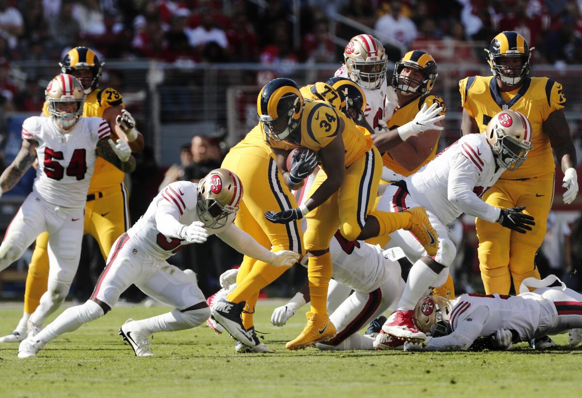 Rams running back Malcolm Brown (34) breaks though defenders as 49ers cornerback D.J. Reed (32) goes for the tackle at Levi's Stadium on Oct. 21.