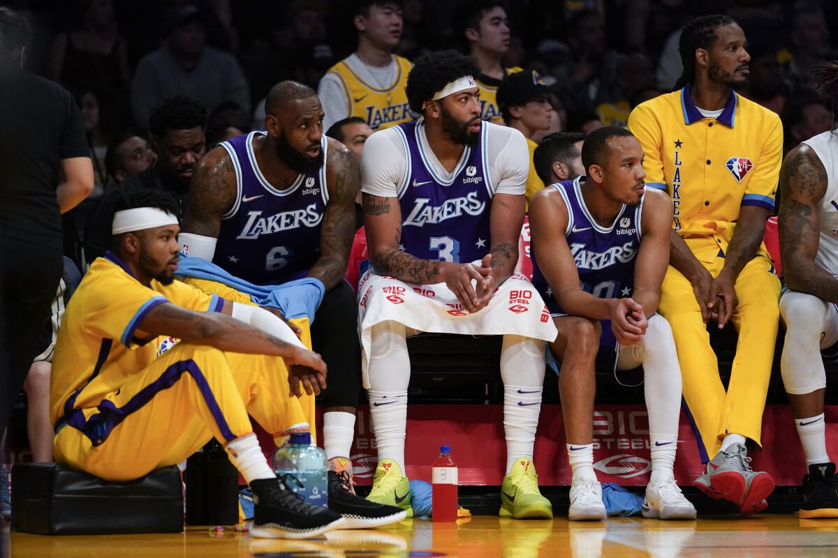 Lakers forward LeBron James, forward Anthony Davis and other players sit on the bench