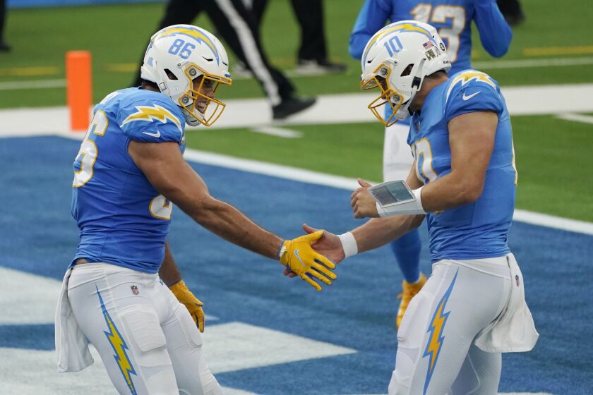 Chargers quarterback Justin Herbert, right, celebrates after throwing a touchdown pass to tight end Hunter Henry.