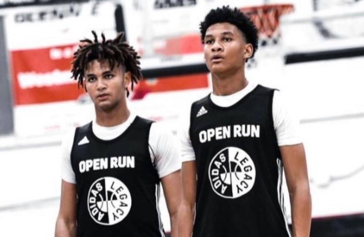 Brothers Marcus and Maxie Adams stand side by side in uniforms.