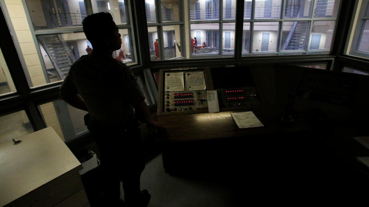 Sheriff's deputy Lee Lee looks over a holding block inside the Fresno County jail.