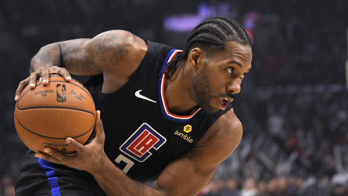 Clippers forward Kawhi Leonard surveys the Nuggets' defense during a game on Feb. 28 at Staples Center.