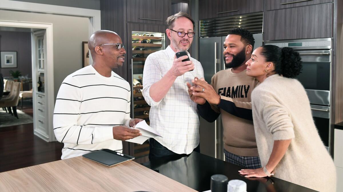 The new new co-showrunners of "black-ish," Kenny Smith, left, and Jonathan Groff, talk with actors Anthony Anderson and Tracee Ellis Ross at the studios in Burbank.