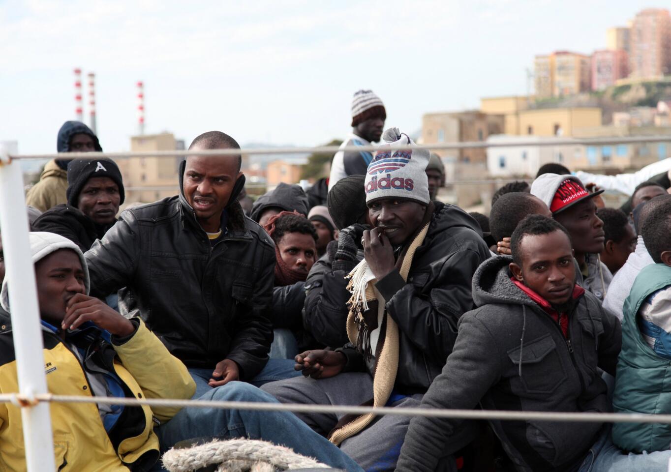 Migrants wait to disembark from an Italian coast guard vessel after being rescued in Porto Empedocle, Sicily.