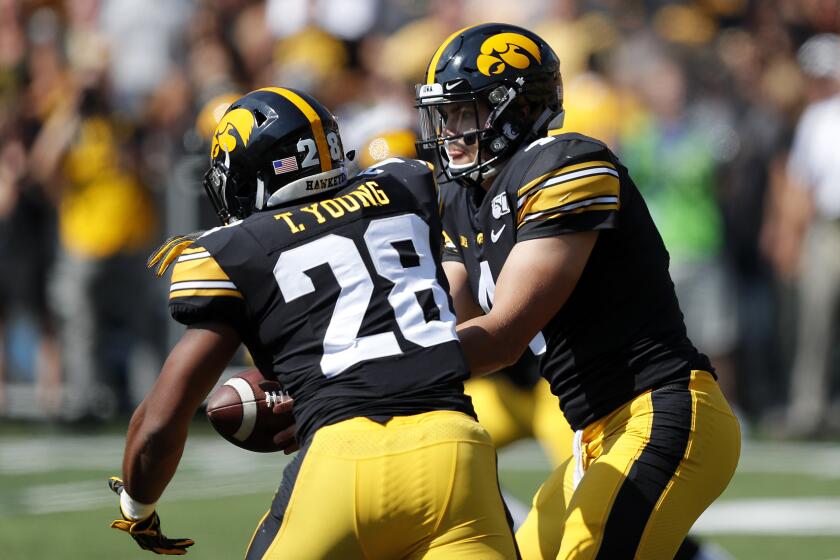 Iowa quarterback Nate Stanley, right, hands off to Iowa running back Toren Young, left, during the first half of an NCAA college football game against Rutgers, Saturday, Sept. 7, 2019, in Iowa City. (AP Photo/Matthew Putney)
