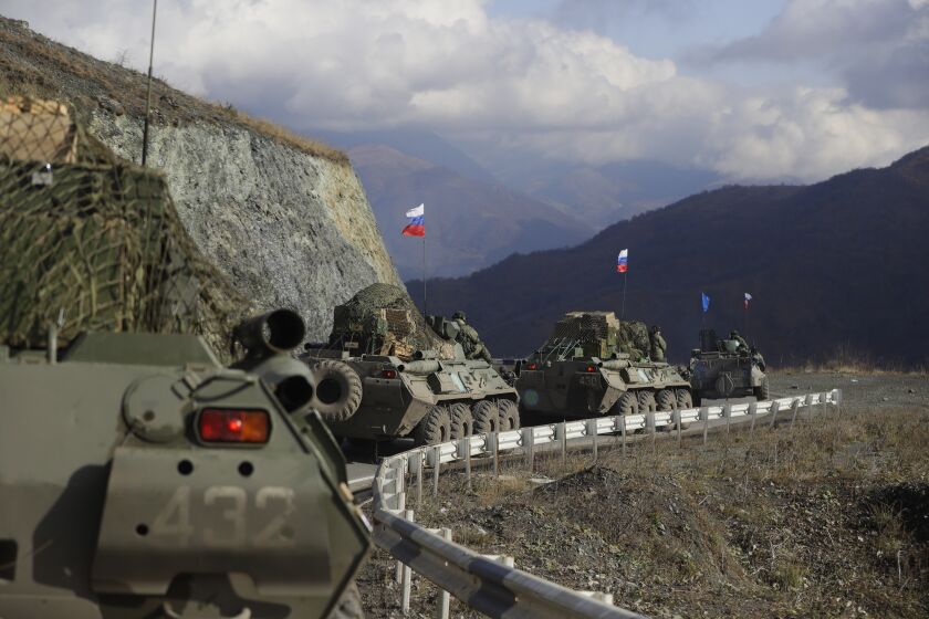 FILE - Russian military vehicles roll along a road towards the separatist region of Nagorno-Karabakh, Friday, Nov. 13, 2020. The war ended with a Russia-brokered armistice under which Azerbaijan regained control of parts of Nagorno-Karabakh and all the surrounding territory previously occupied by Armenians. Russia sent a peacekeeping force of 2,000 troops to maintain order, including ensuring that the Lachin Corridor remained open. (AP Photo/Sergei Grit, File)