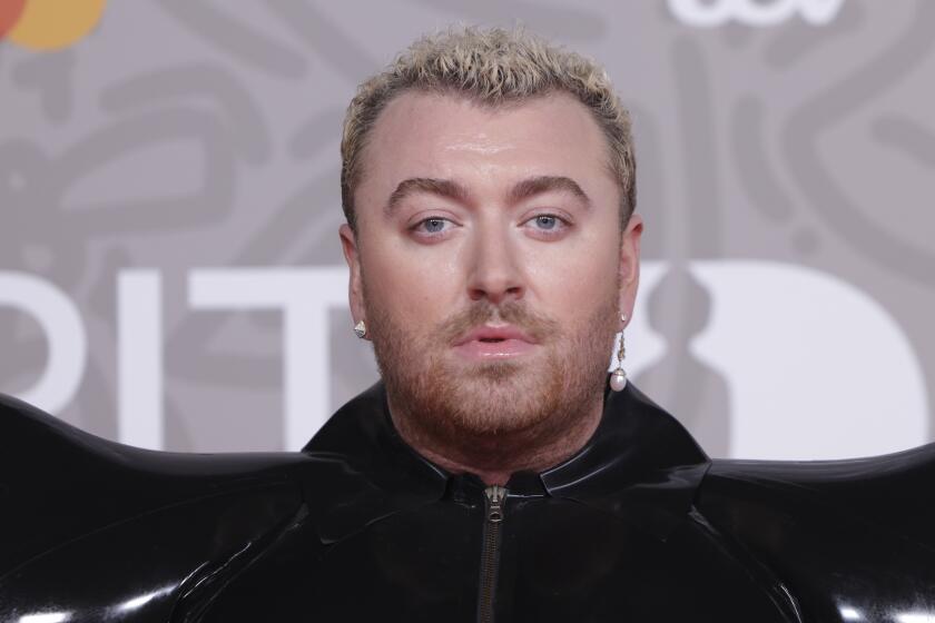 A close up of Sam Smith posing for photographers 