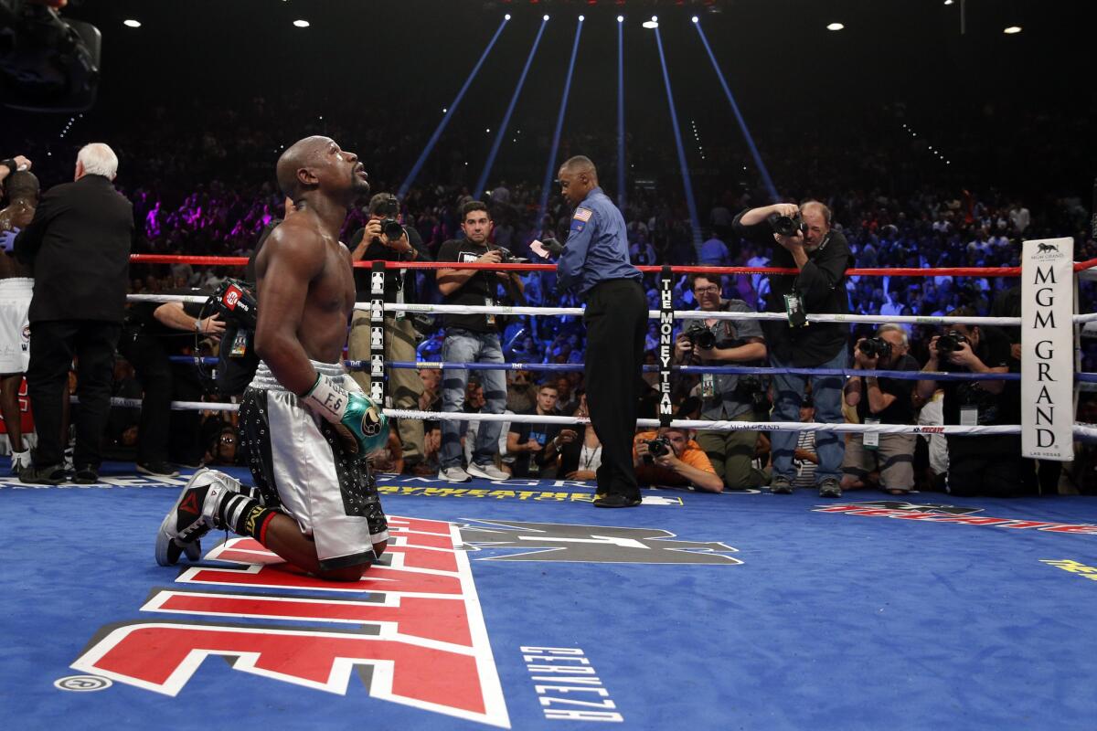 Floyd Mayweather Jr. drops to his knees at the end of his welterweight title bout against Andre Berto on Saturday.