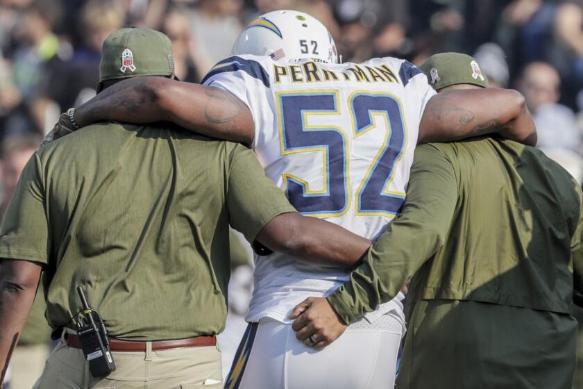 OAKLAND, CA, SUNDAY, NOVEMBER 11, 2018 - Chargers linebacker Denzel Perryman is helped off the field after sustaining an injury to his left knee on the second play from scrimmage against the Raiders at Oakland-Alameda County Coliseum. (Robert Gauthier/Los Angeles Times)