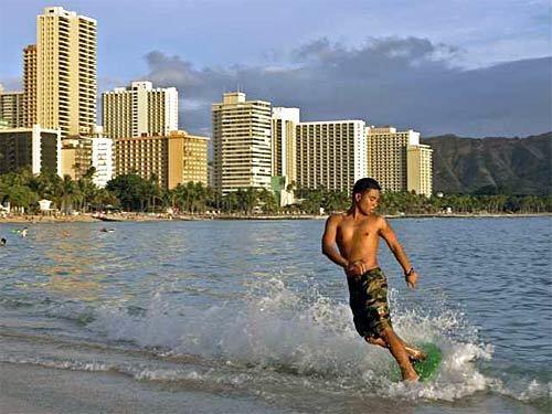 A surfer on a skim board at Waikiki Beach.
