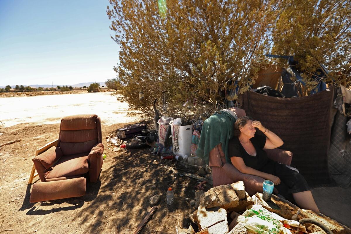 Roberta Massie, 63, sits in a chair at her encampment in Lancaster. "This is where you end up: the horrible, desolate desert," Massie said. Sickly and with arthritis in one of her feet. L.A. Family Housing was able to find her housing in October.