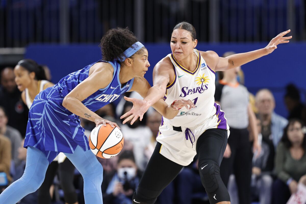 Sparks center Liz Cambage takes a swipe at the ball while defending Sky forward Candace Parker.