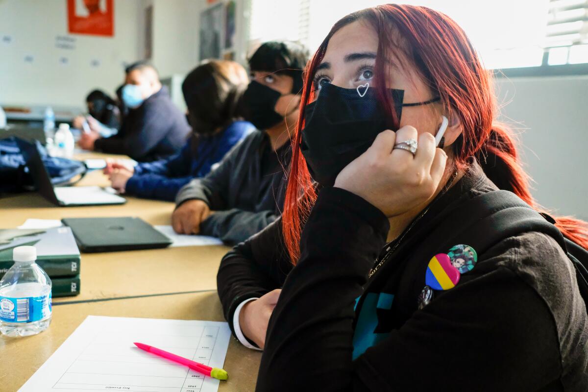 Masked students listen in class.