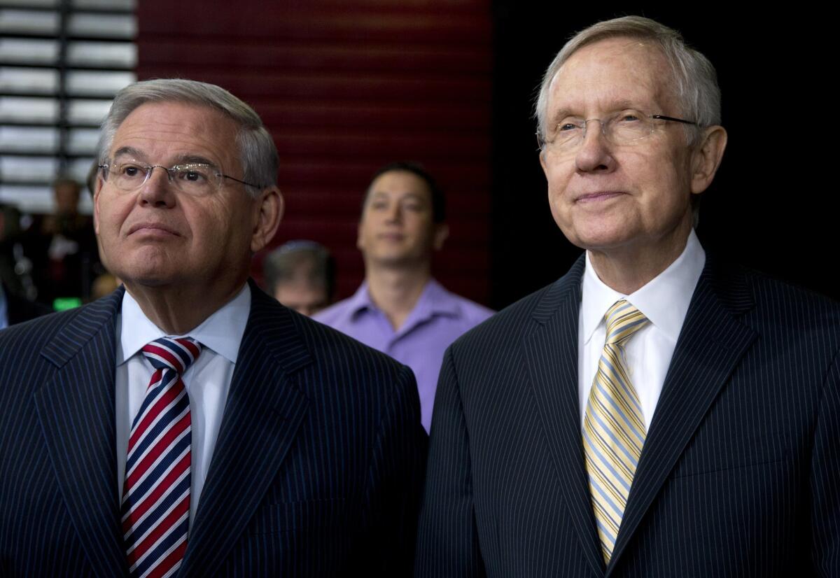 Senate Majority Leader Harry Reid (D-Nev.), right, and Senate Foreign Relations Committee Chairman Robert Menendez (D-N.J.) look on as President Obama discusses new immigration policies in Las Vegas on Friday.