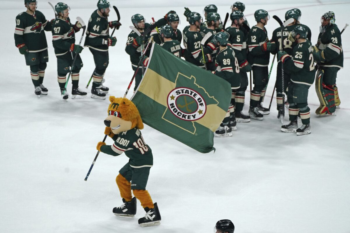 Minnesota Wild players celebrate after defeating the Colorado Avalanche 4-1in an NHL hockey game Friday, April 29, 2022, in St. Paul, Minn. The Wild will face the St. Louis Blues in the first round of the Stanley Cup playoffs. (AP Photo/Jim Mone)