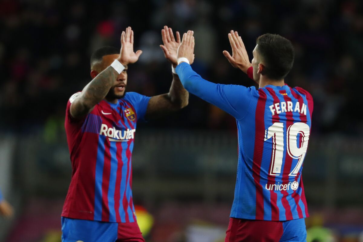 Barcelona's Ferran Torres, right, and Memphis Depay celebrate after the Spanish La Liga soccer match between FC Barcelona and Sevilla at the Camp Nou stadium in Barcelona, Spain, Sunday, April 3, 2022. (AP Photo/Joan Monfort)