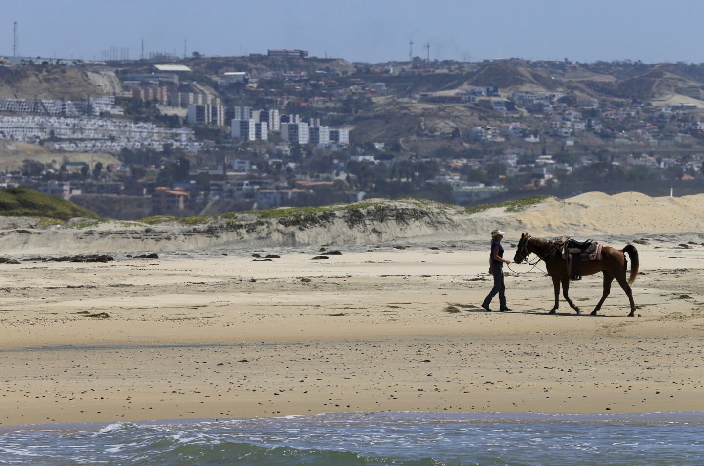 A woman takes a break from riding her horse on Imperial Beach, one of only a few places along the coast where horses are allowed.