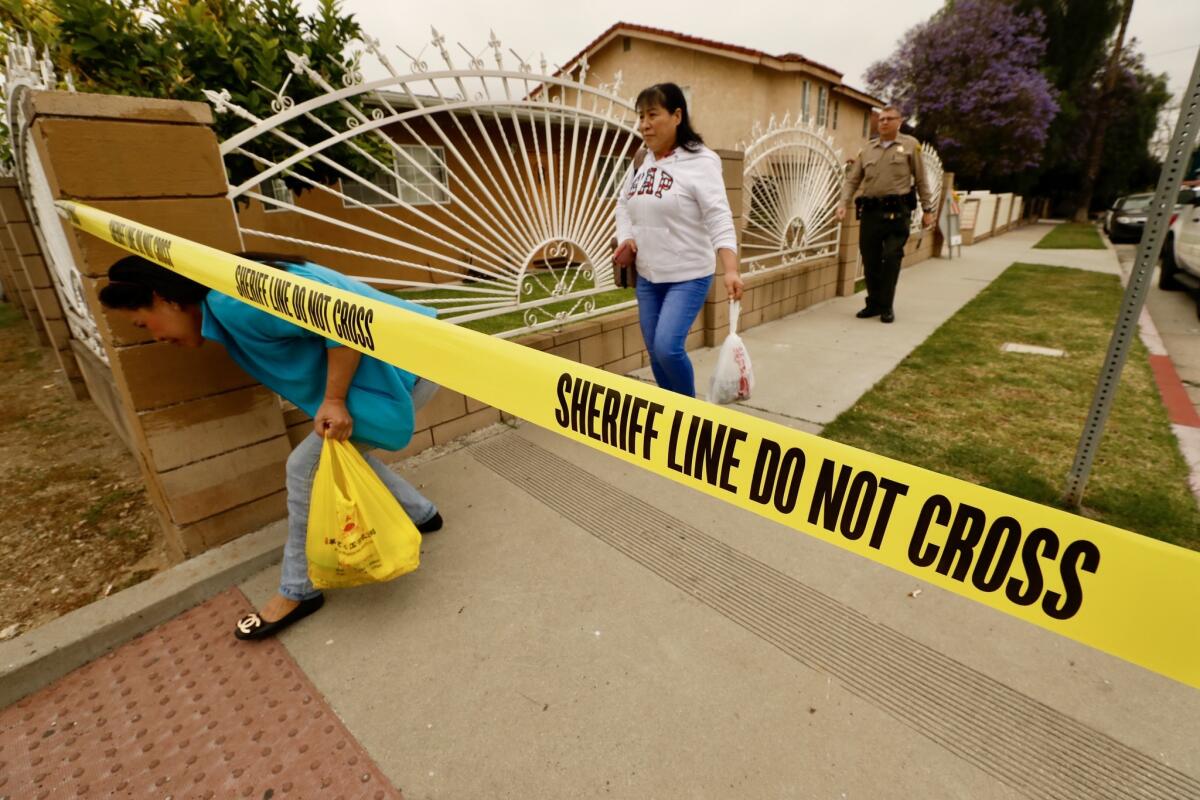 An L.A. County sheriff's deputy evacuates a San Gabriel neighborhood.