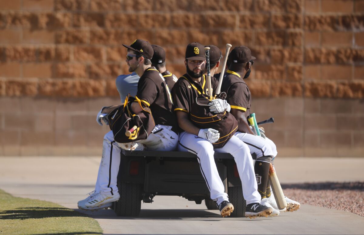 Padres players ride on a golf cart to a field during a spring training practice on Feb. 20, 2020.