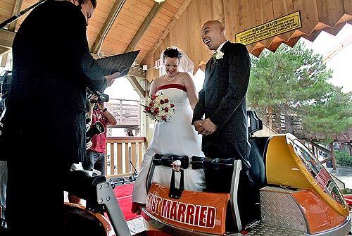 Pastor Drew Koen presides over the wedding for Nicole Crabtree and Nathan Venderweit, who said their " I do's" aboard a Knott's Berry Farm's roller coaster on Tuesday.