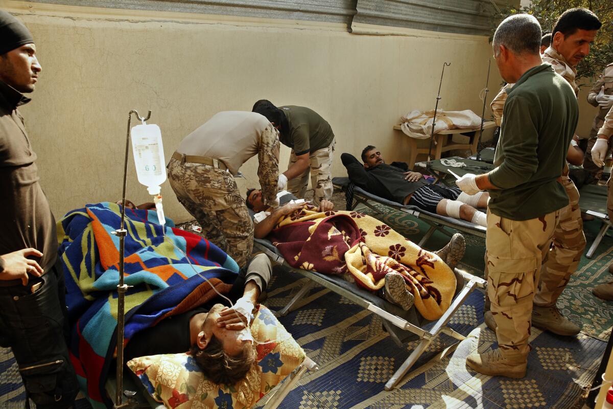 Maj. Gen. Raad Mohssan Dakhel treats a soldier hit by shrapnel from a car bomb.