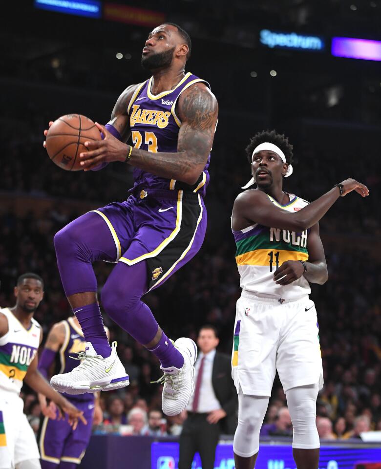 Lakers star LeBron James goes up for a dunk in front of Pelicans guard Jrue Holiday during the second quarter of the Lakers' 125-119 victory at Staples Center on Feb. 27.