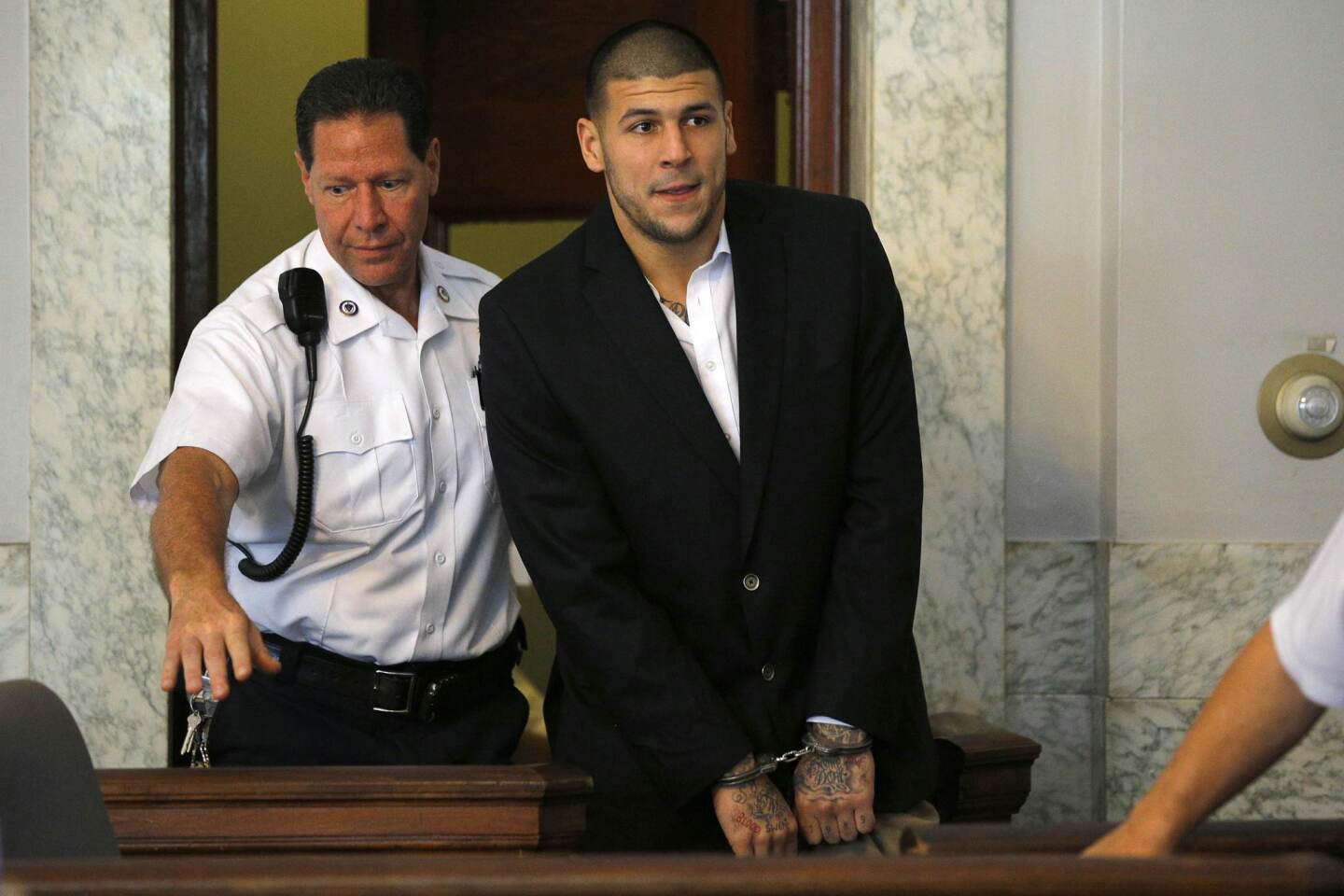 Aaron Hernandez, former player for the NFL's New England Patriots football team, enters the courtroom