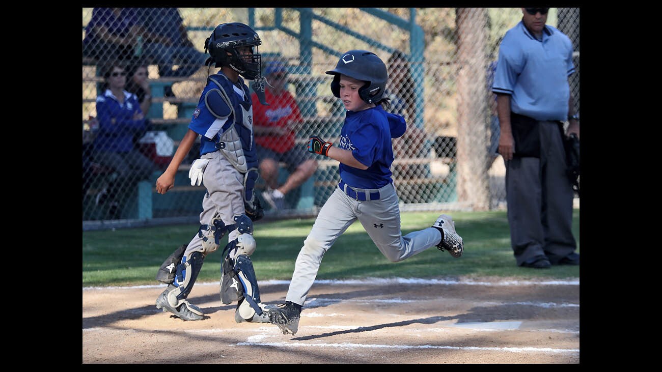 Crescenta Valley baseball player Aiden Lee scores after being walked in Minor Little League game vs. Burbank, at Tujunga Little League Fields in Tujunga, on Tuesday, June 5, 2018.