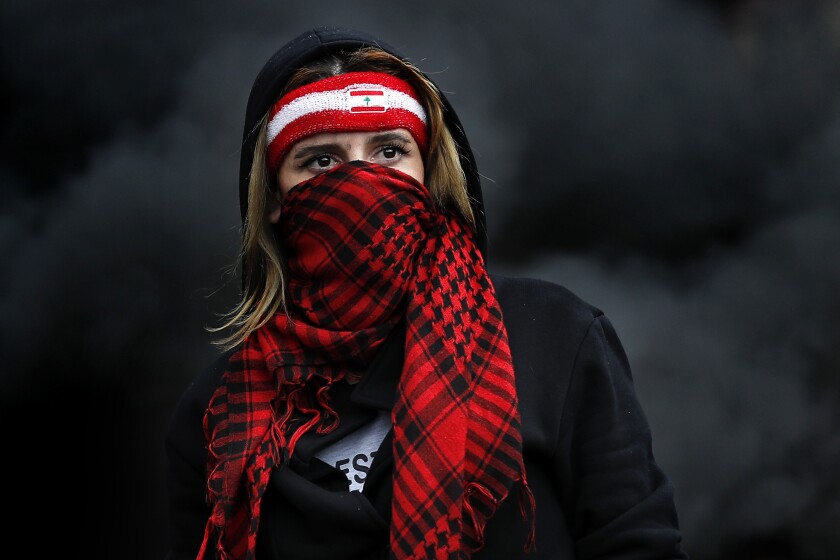 Una joven se cubre el rostro con una bufanda durante manifestaciones antigubernamentales