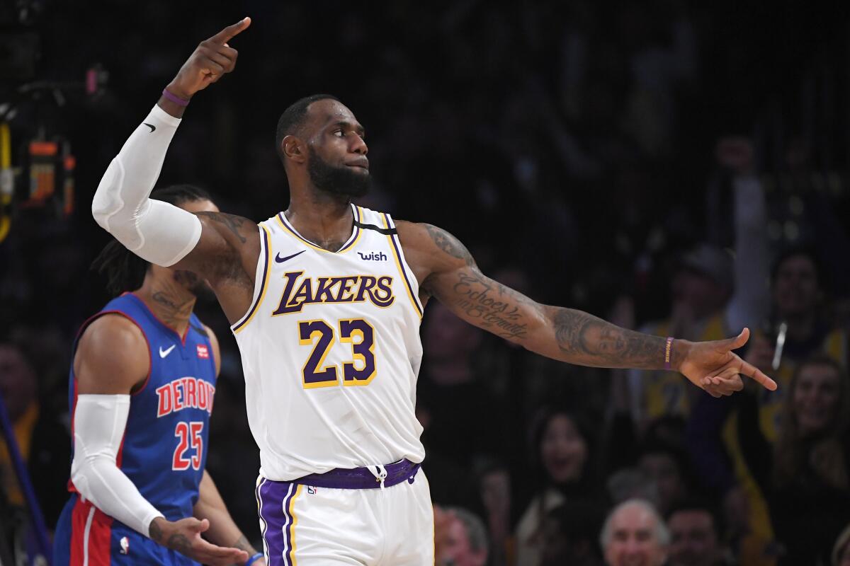 Los Angeles Lakers forward LeBron James, right, celebrates after the Lakers scored as Detroit Pistons guard Derrick Rose stands by during the second half of an NBA basketball game Sunday, Jan. 5, 2020, in Los Angeles. The Lakers won 106-99.