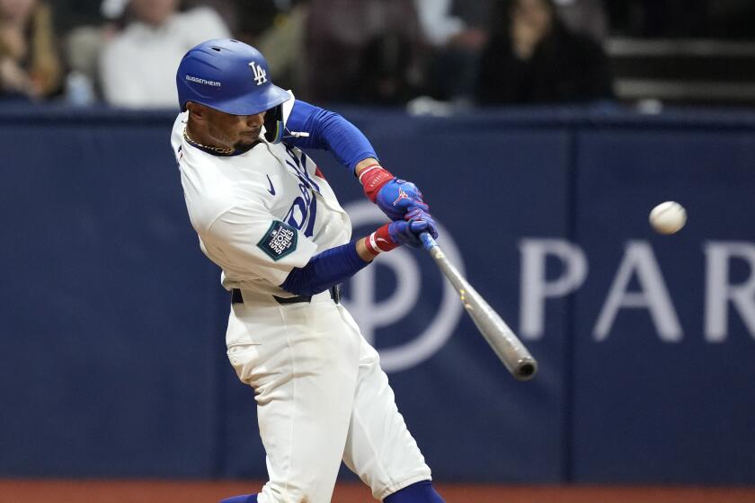 Los Angeles Dodgers' Mookie Betts hits a solo home run during the fifth inning of a baseball game.