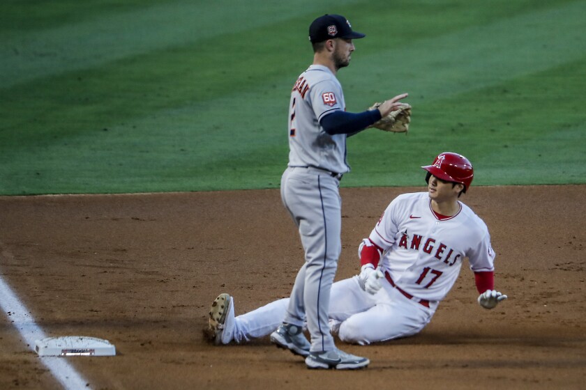 Angels pitcher Shohei Ohtani slides safely into third base with a second inning triple.