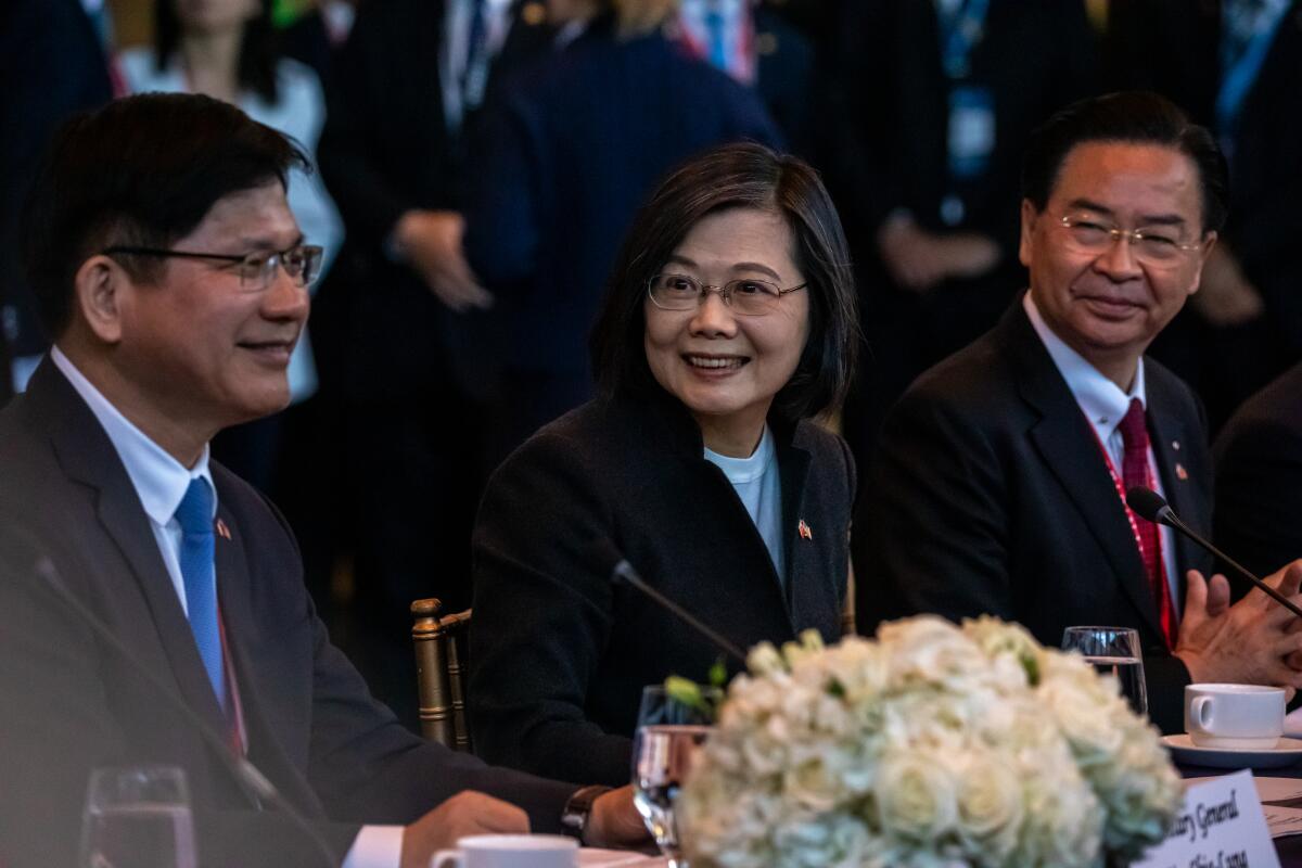 Taiwanese President Tsai Ing-wen sits with two members of her traveling delegation