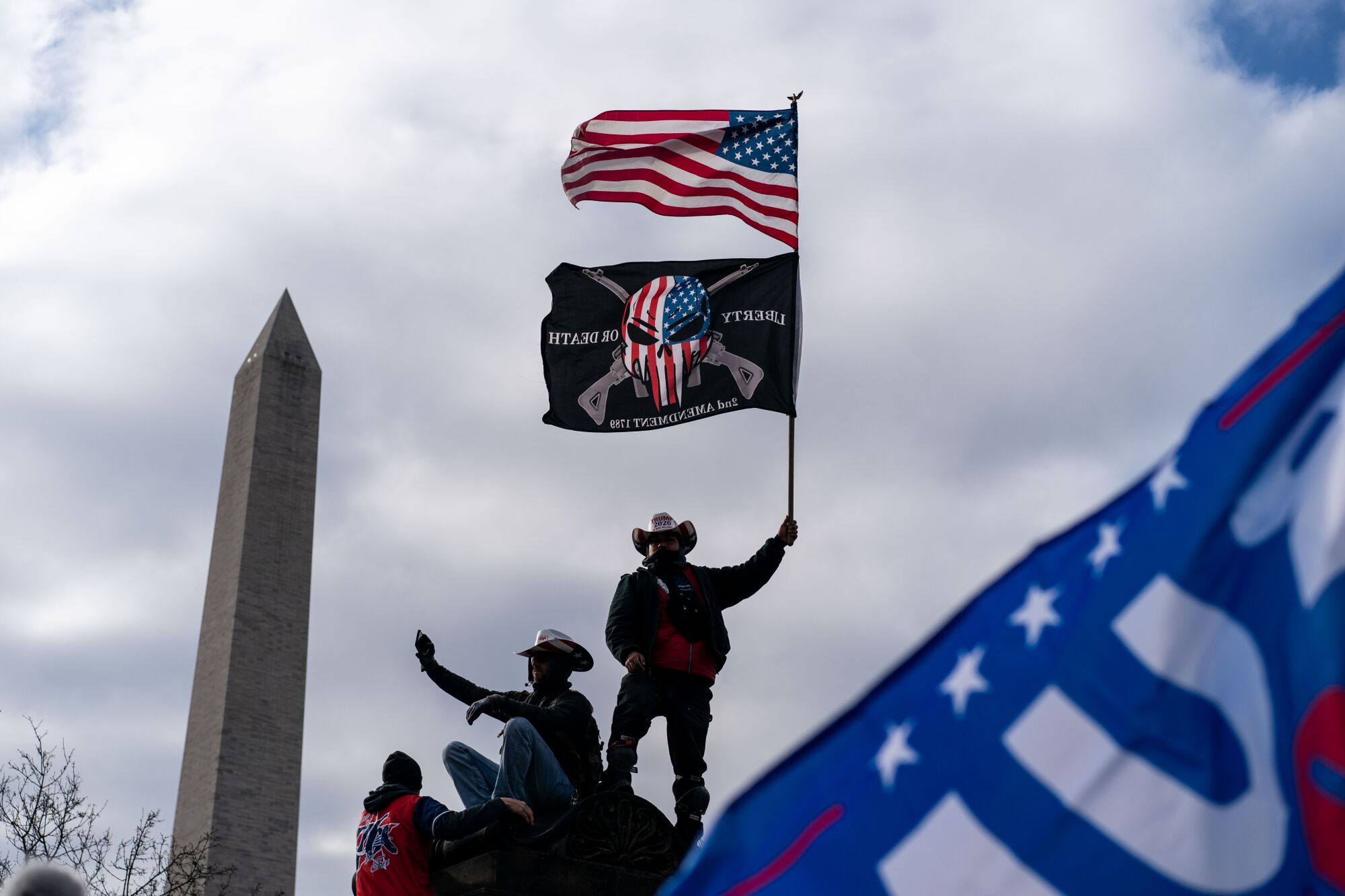 Donald Trump supporters hold flags and take a selfie with the Washington Monument in the background