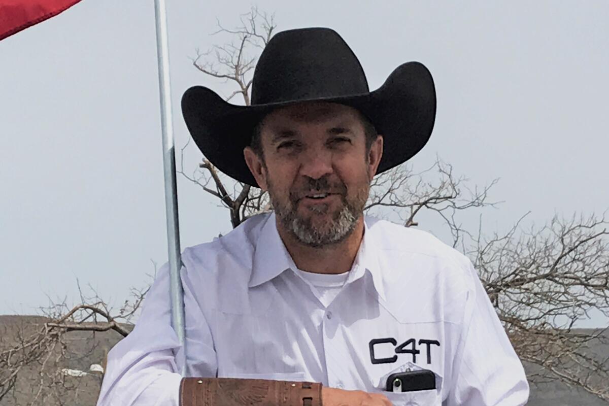 Couy Griffin in a black cowboy hat and a white shirt with 'C4T' above the breast pocket.