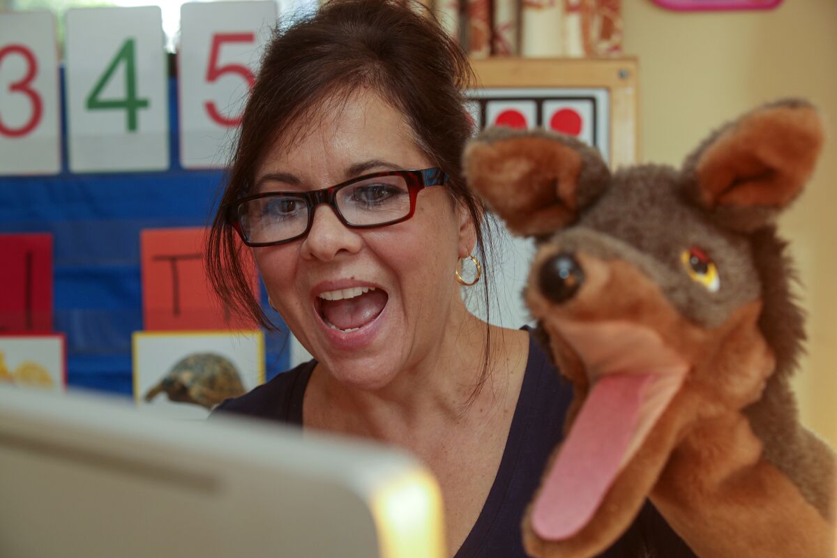 Mrs. Carter uses a hand puppet in an online lesson.