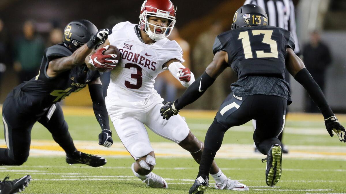 Baylor safeties Terrell Burt (13) and Calvin Hill attempt to tackle Oklahoma wide receiver Sterling Shepard (3) in the second half Saturday.