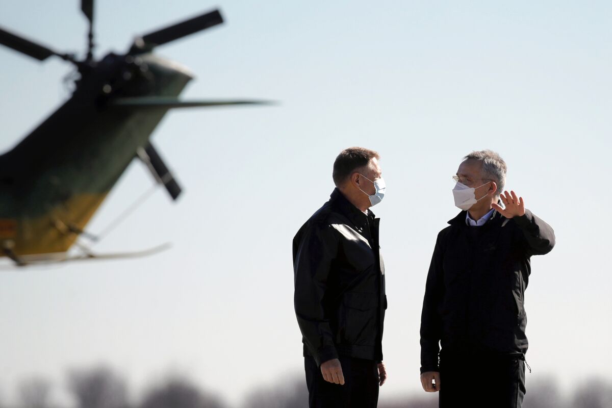 NATO Secretary General Jens Stoltenberg, right, and Romania's President Klaus Iohannis inspect the Mihail Kogalniceanu airbase, near the Black Sea port city of Constanta, eastern Romania, Friday, Feb. 11, 2022. Stoltenberg paid an official visit to Romania on Friday, where he joined the country’s president at a military airbase that will host some of the 1,000 U.S. troops deployed to the country as the alliance bolsters its forces on the eastern flank as tensions soar between Russia and Ukraine. (AP Photo/Andreea Alexandru)