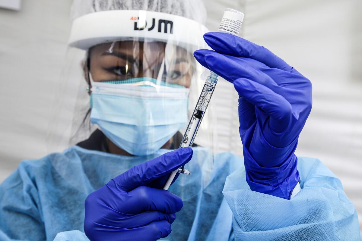 A nurse prepares a dose of COVID-19 vaccine.