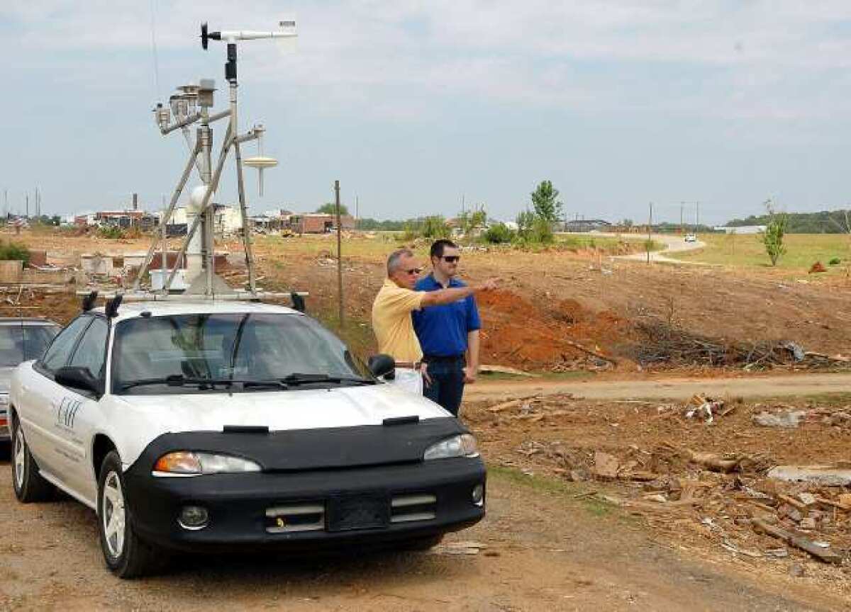 Professor Kevin Knupp, left, and student Todd Murphy visit Hackleburg, Ala., in their Mobile Meteorological Measurement Vehicle. Getting to such sites before tornado damage is cleaned up is crucial to their research.