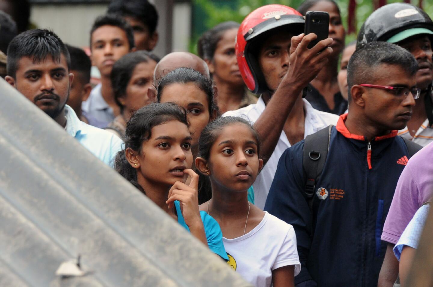 Residents watch as military rescue workers search for survivors of a mudslide in Bellana village in Kalutara.