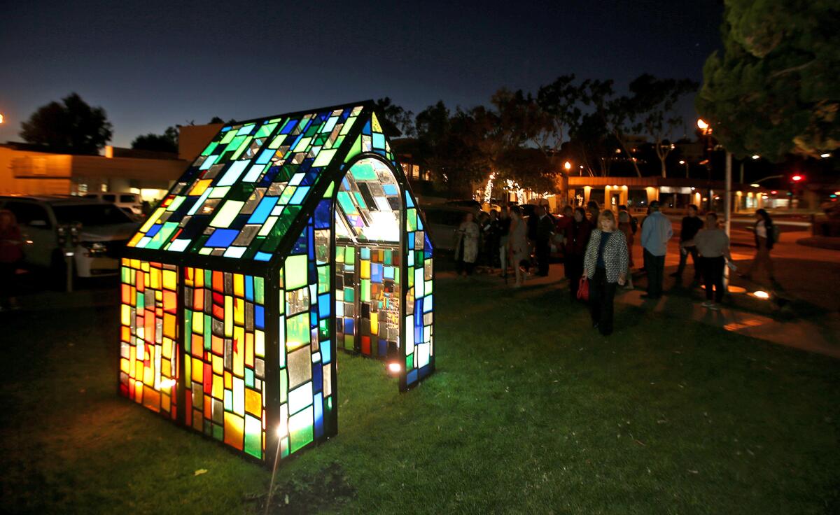 "Camouflage House" stands on the lawn outside Laguna Beach City Hall during its reveal ceremony Monday evening. "Camouflage is kind of a misnomer because it's so vibrant," artist Tom Fruin says. "It has two sides. One is ... colors like orange, yellows and red and the other side is more grassy and mossy."
